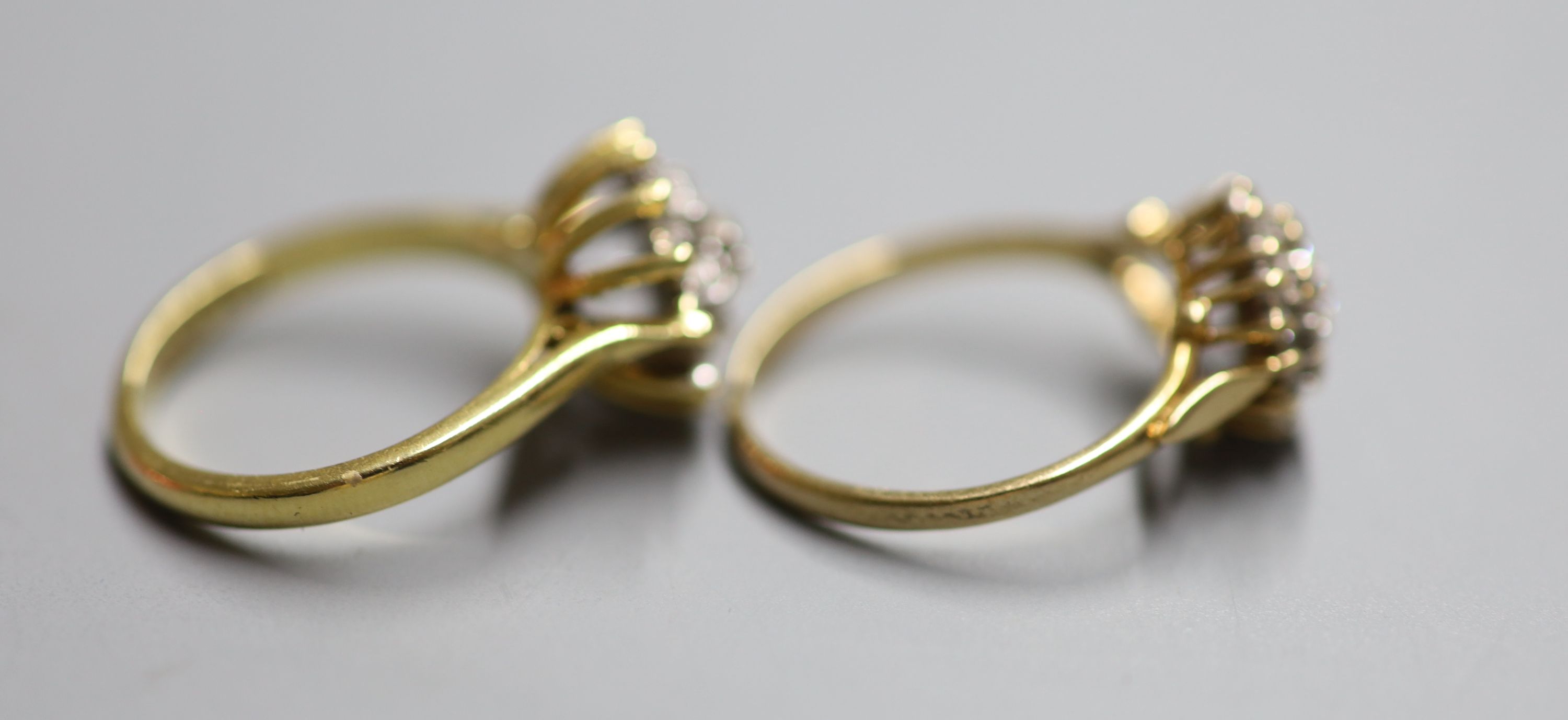 Two modern 18ct gold and diamond cluster dress rings, sizes J/K & N, gross weight 7.4 grams.